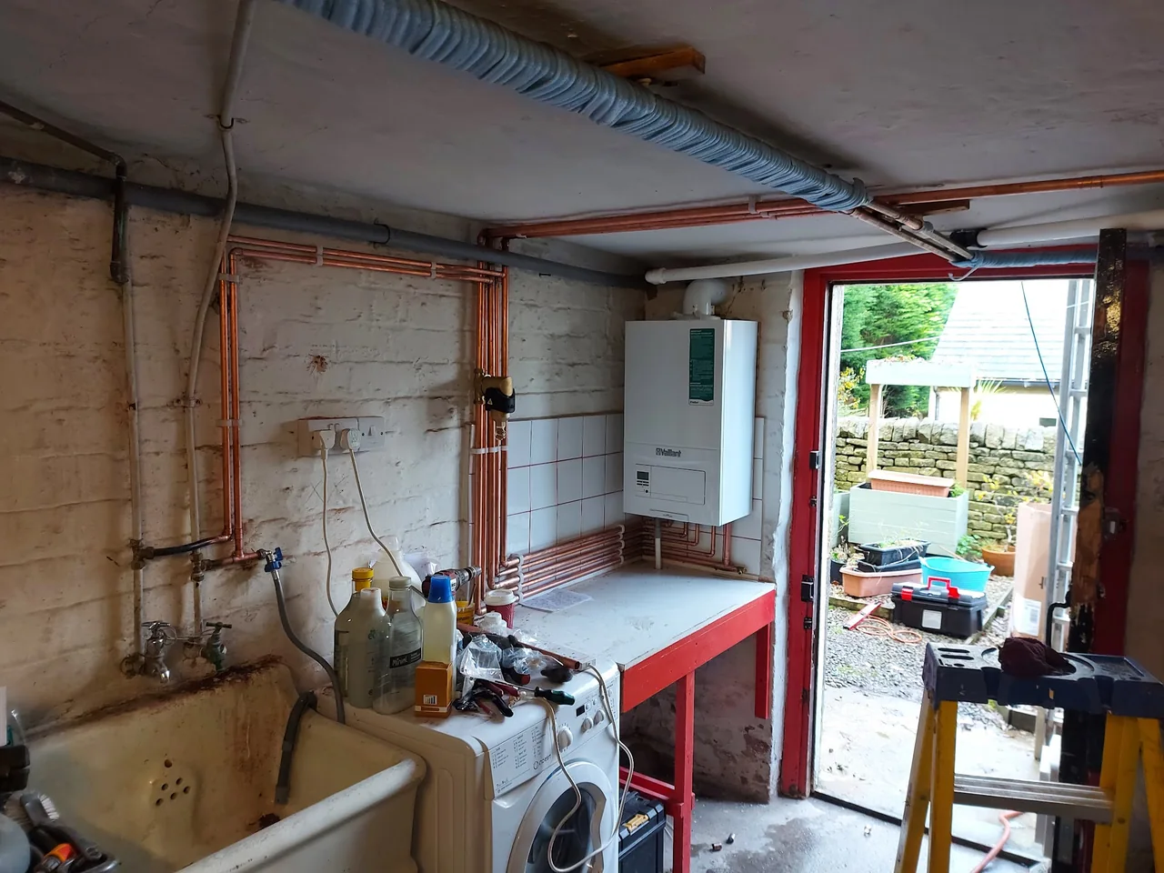Wall-mounted boiler and copper pipework in a utility room